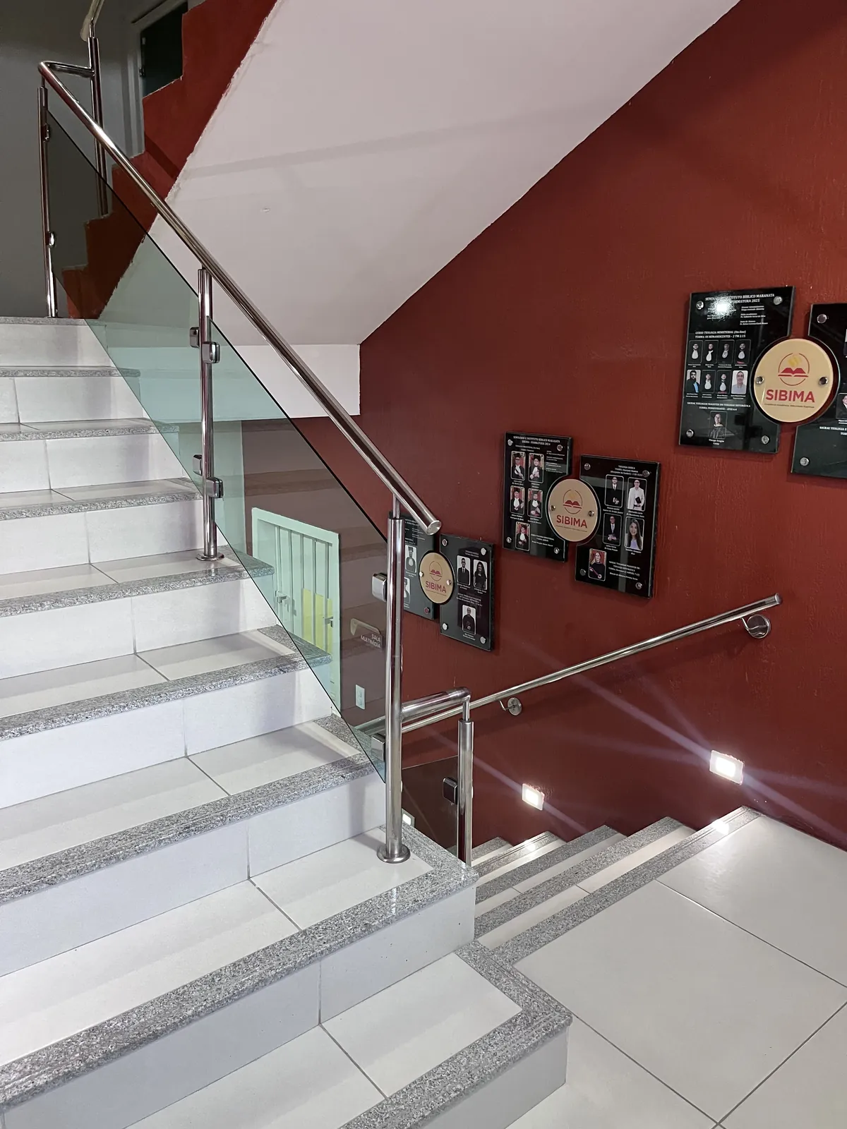 Escada do SIBIMA com mural de fotos de turmas formadas